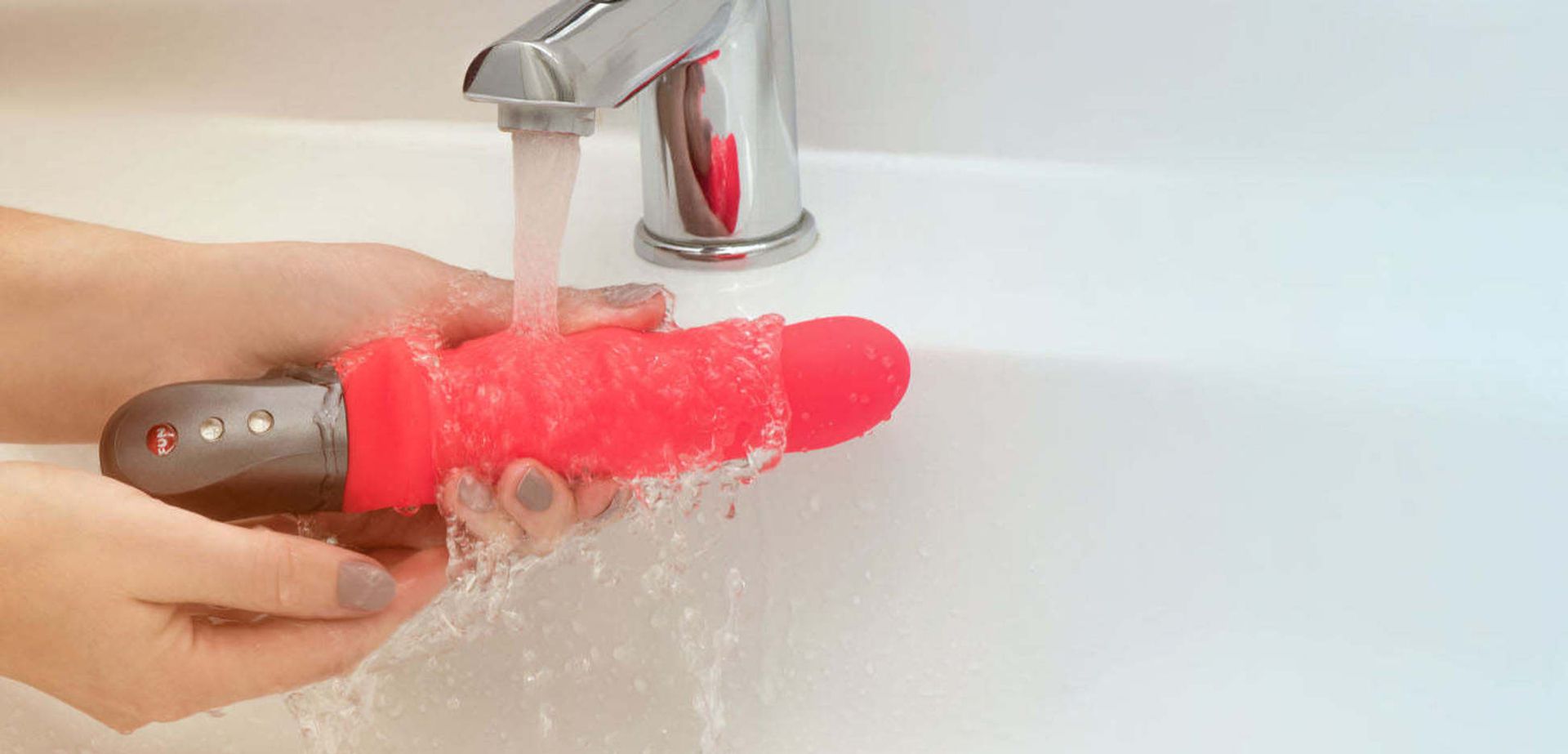 Cleaning a dildo with water.