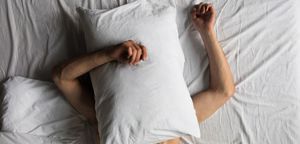 Man in a bed with a pillow.