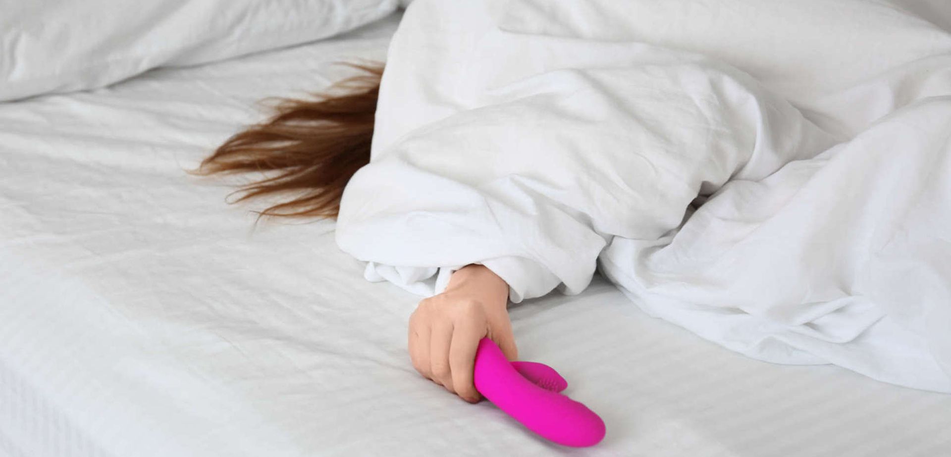 Womam in bed with a dildo.